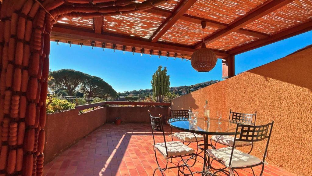 un patio avec une table et des chaises sur un patio dans l'établissement Paisible T2- PLages et Commerces, au Lavandou