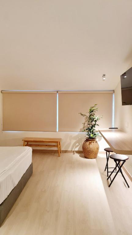 a bedroom with a bed and a table and a potted plant at Kazuki Boutique Accommodation in George Town