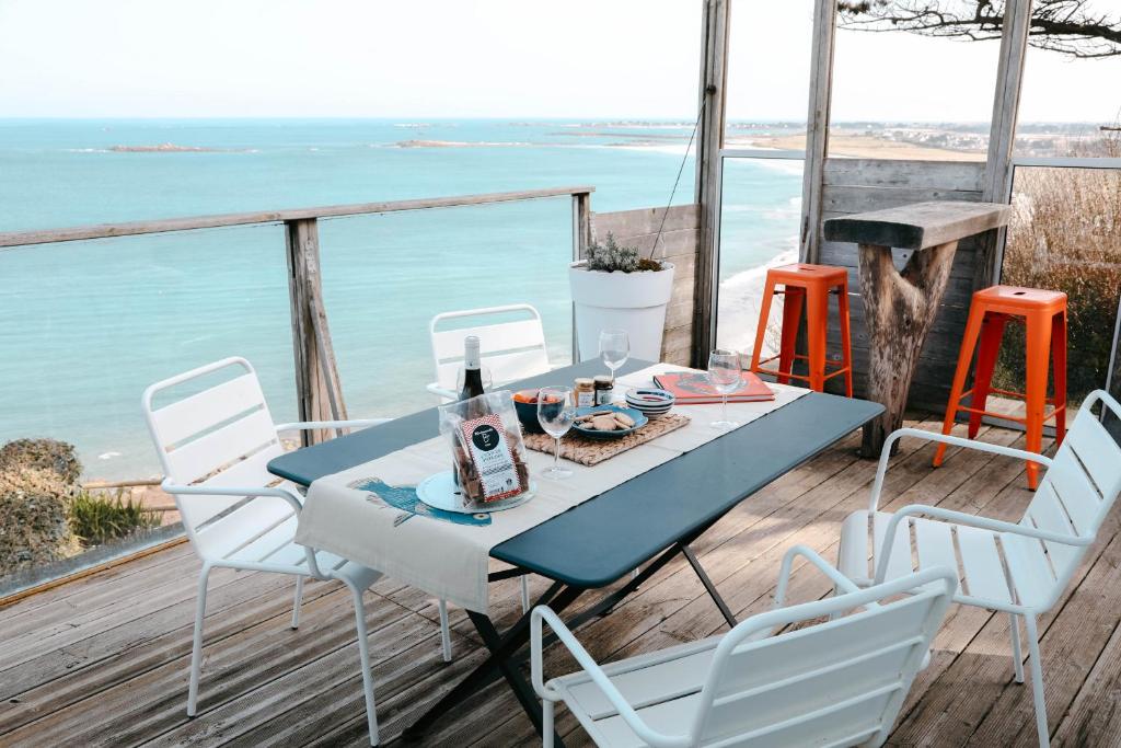 - une table et des chaises sur une terrasse avec vue sur l'océan dans l'établissement Terrasse face à l'océan pour 4 personnes, à Plouguerneau