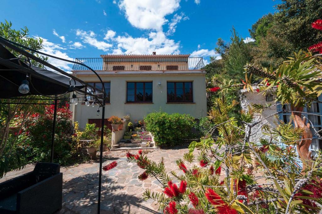 une maison avec beaucoup de fleurs devant elle dans l'établissement T4 , Jardin arboré et plages à moins de 5 min à pieds, à Bormes-les-Mimosas