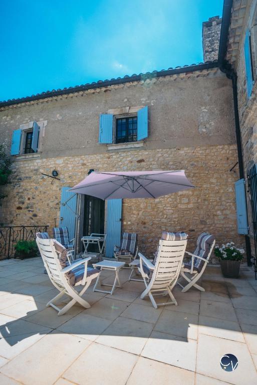un groupe de chaises et un parasol sur une terrasse dans l'établissement Studio 2, à Saint-Montan