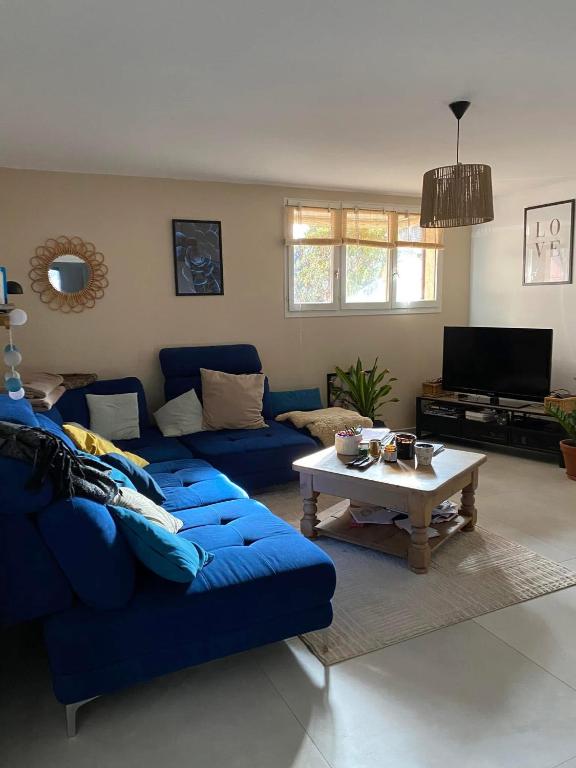 un salon avec un canapé bleu et une table basse dans l'établissement Appartement 500m de la plage, à Sainte-Maxime