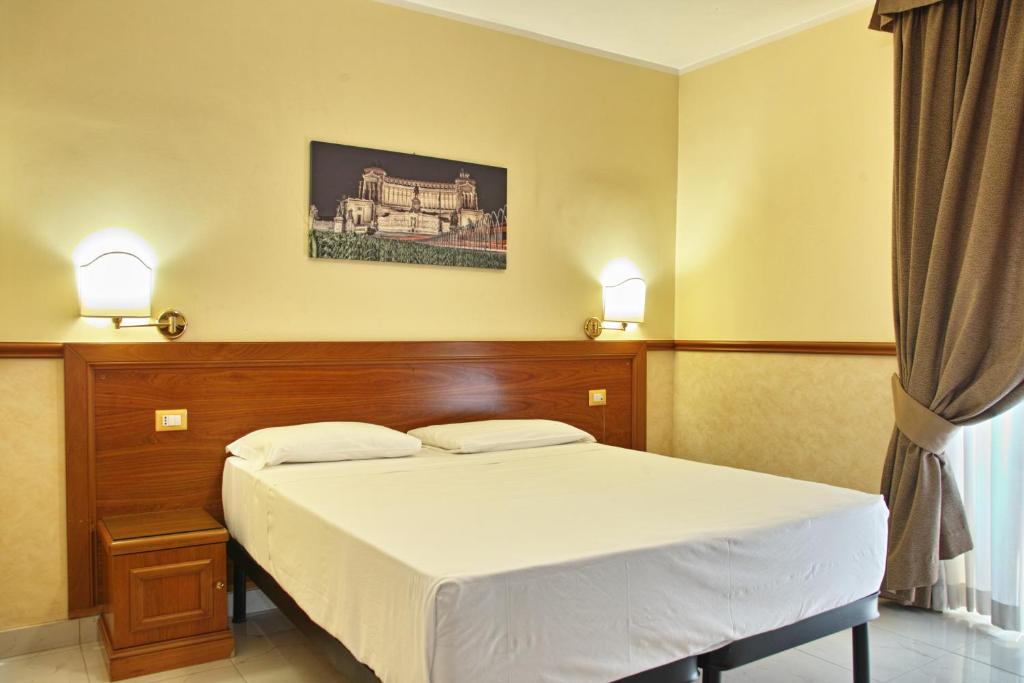 a bedroom with a bed and two lamps on the wall at Ghv Rooms Roma in Rome