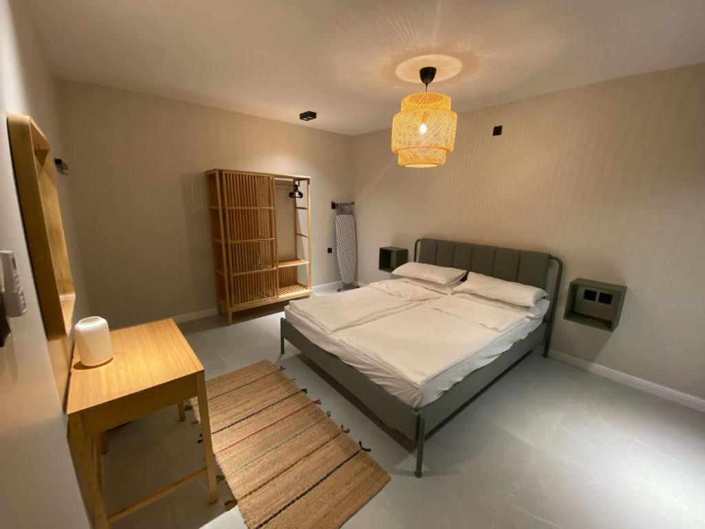 ein Schlafzimmer mit einem Bett, einem Tisch und einer Lampe in der Unterkunft Al Salehiyah 2 in Medina