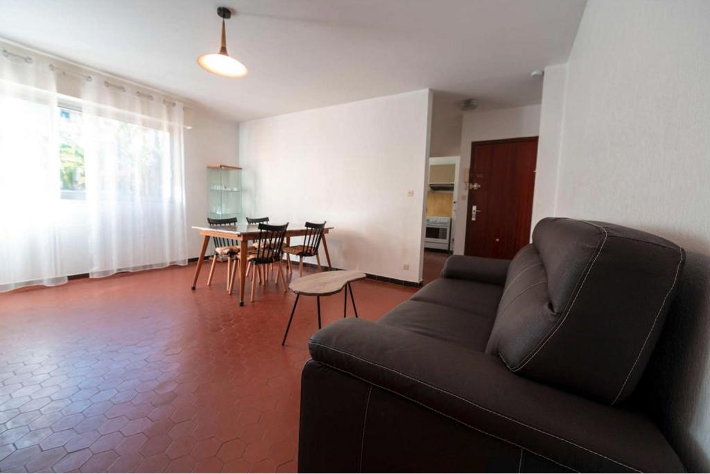 un salon avec un canapé et une table dans l'établissement T2- Piscine- Plages- Commerces, au Lavandou
