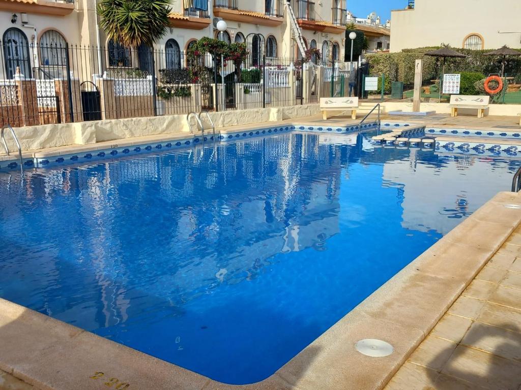 a swimming pool with blue water in front of a building at La Florida Apartment Near Emerald Isle Complex in Orihuela Costa