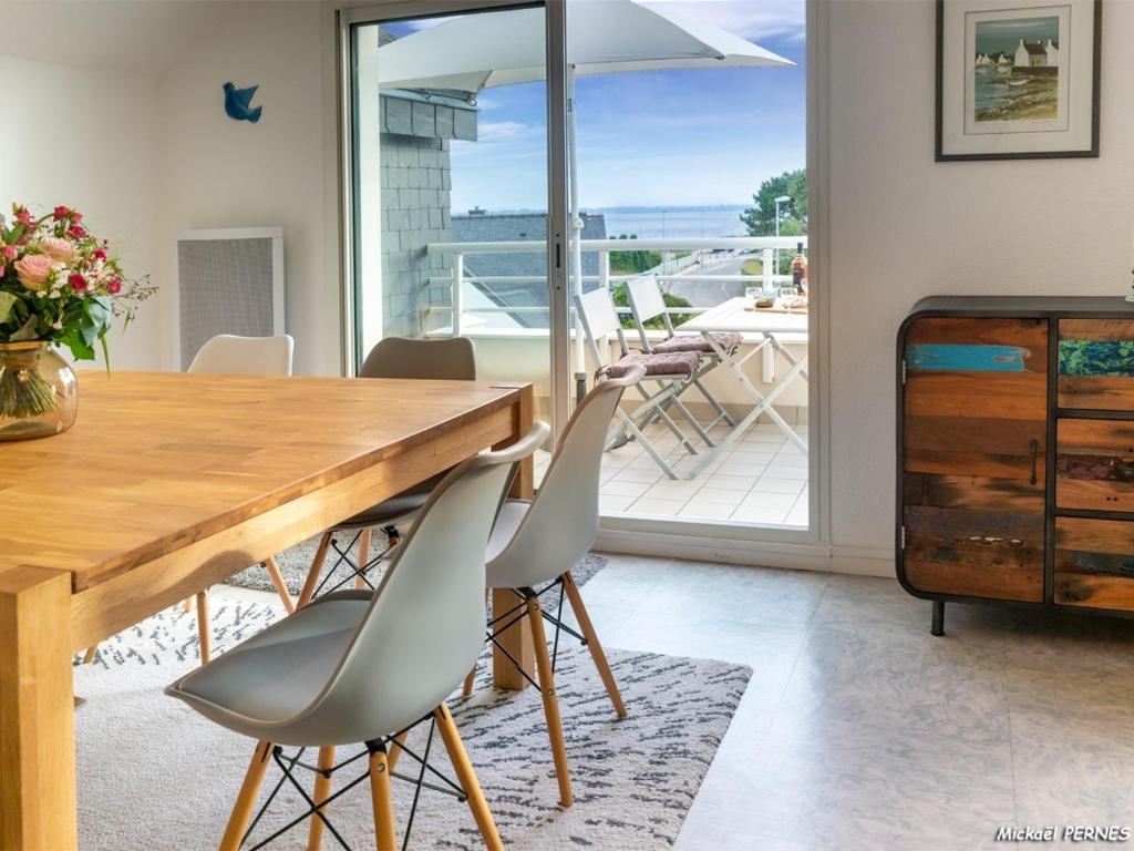 une salle à manger avec une table et des chaises et un balcon dans l'établissement Larmor-Plage : Appartement T3 avec Terrasse et Garage - FR-1-349-155, à Larmor-Plage