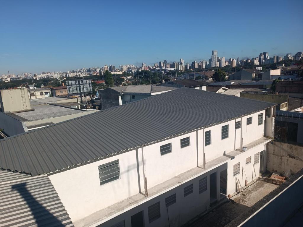 a large white building with a city in the background at Assel Pousada Botanico in Curitiba