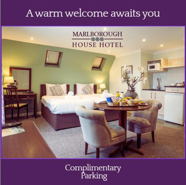 a room with a bed and a table and a kitchen at Marlborough House - Guest House in Oxford