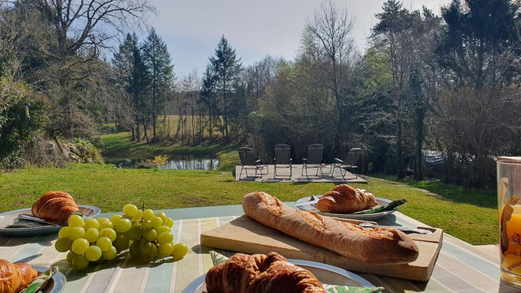 a table with plates of bread and grapes on it at Maison de l'olivier in Champniers-et-Reilhac