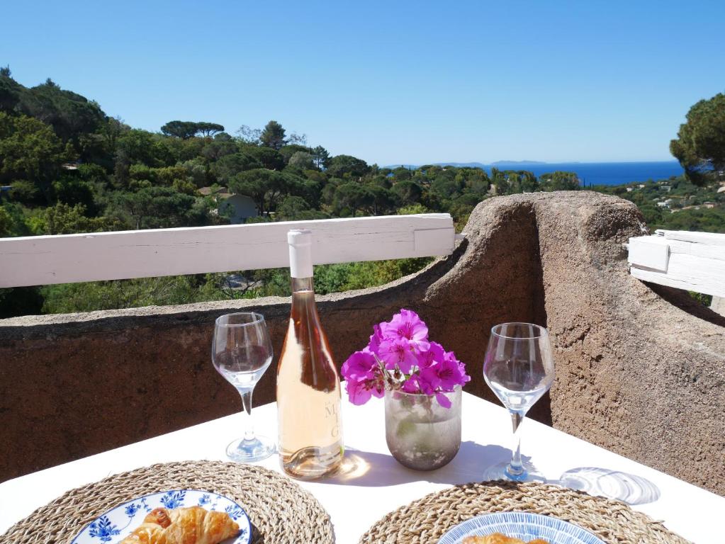- une table avec une bouteille de vin et deux verres dans l'établissement Bel appartement climatisé vue mer Les Mas de Gigaro, à La Croix-Valmer