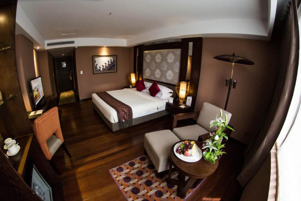 a hotel room with a bed and a table at Rose Garden Hotel in Yangon