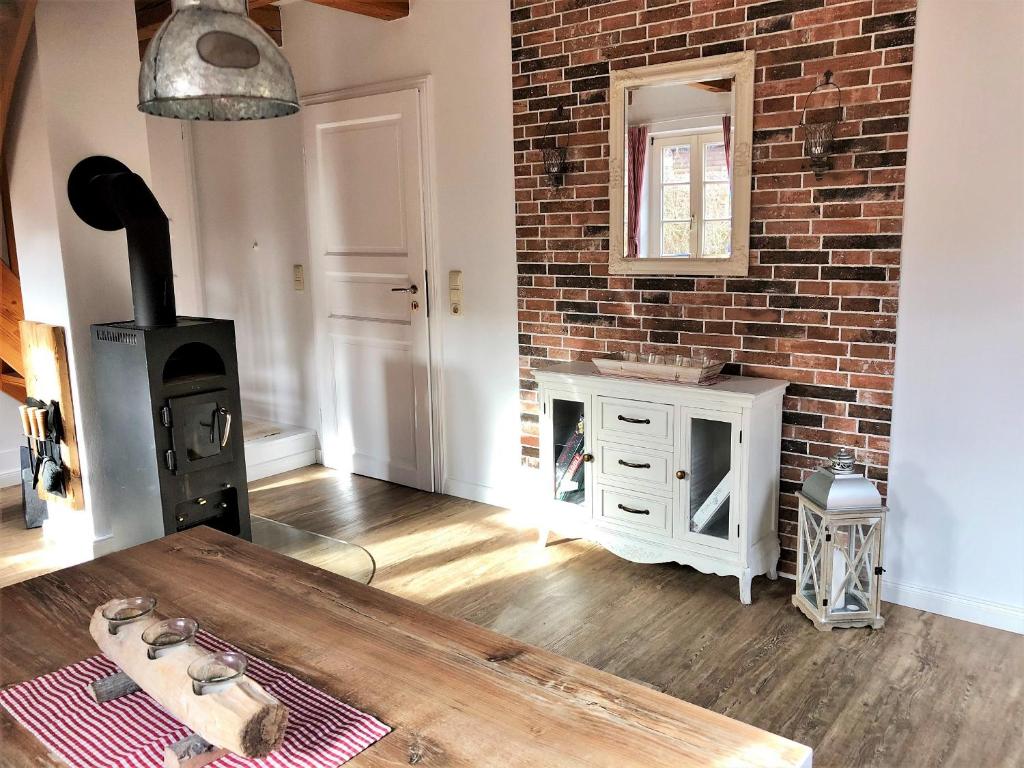 a living room with a brick wall and a wood stove at kleine meerZeit, süßes Knusperhäuschen mit Kaminofen in Fehmarn
