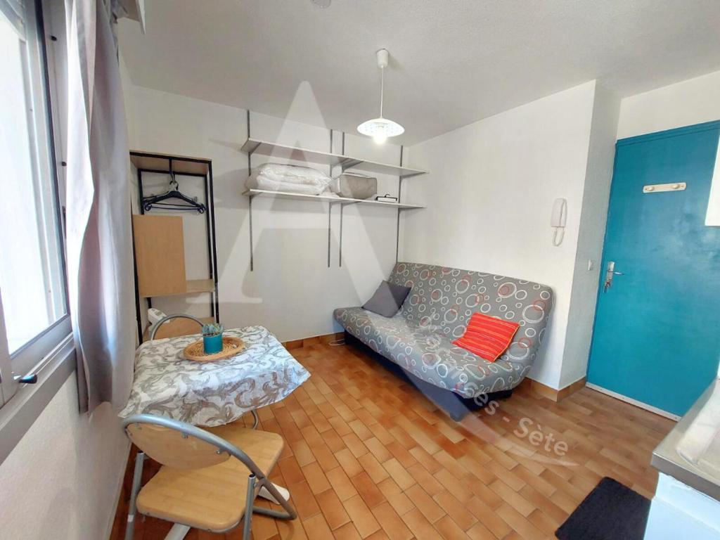 un salon avec un canapé et une table dans l'établissement Studio entre vie de quartier et plages, à Sète