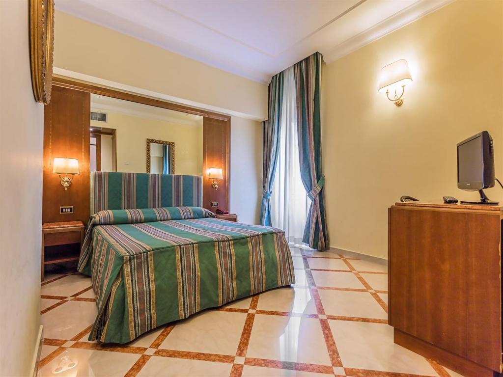 a hotel room with a bed and a television at Raeli Hotel Noto in Rome