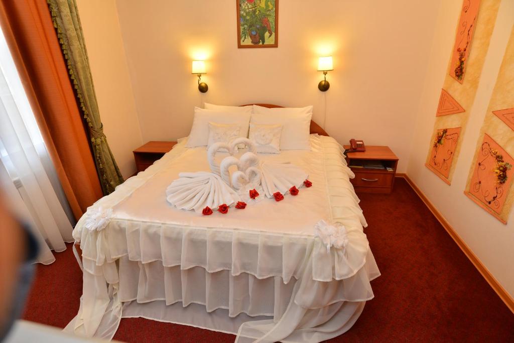 Un dormitorio con una cama blanca con rosas. en Eurohotel Central, en Yekaterinburg