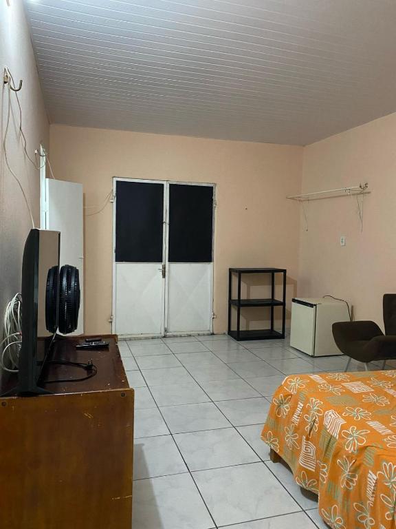 a room with a bedroom with a bed and a tv at Quarto Baturité in Baturité