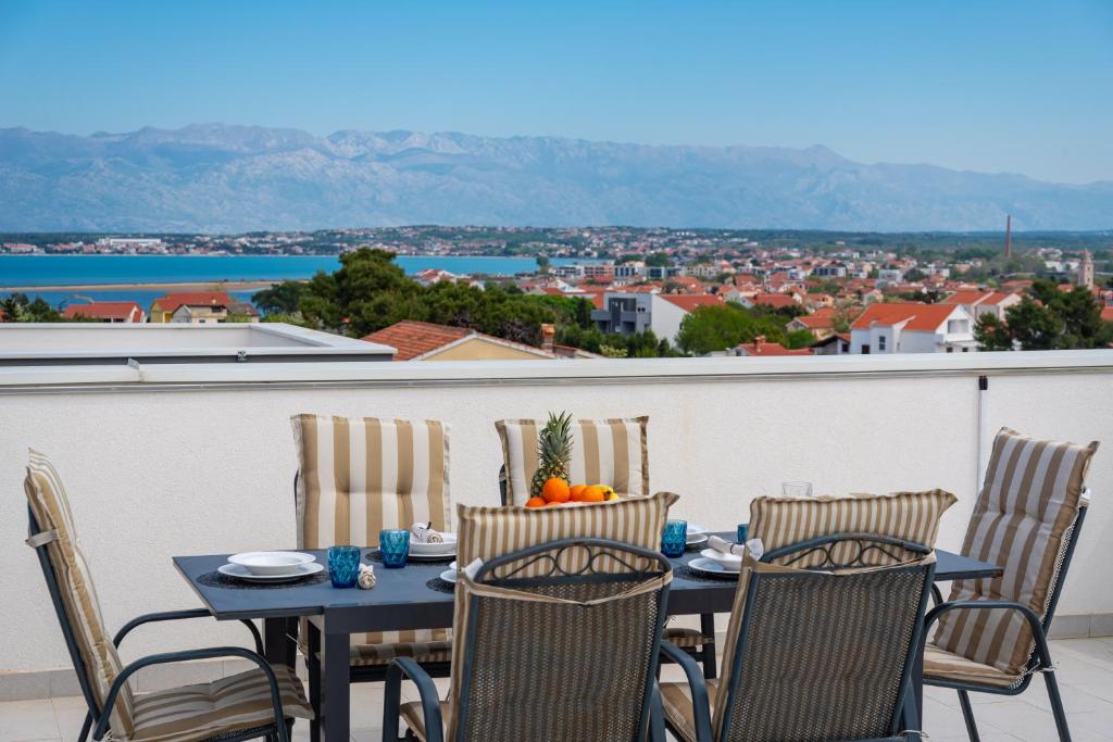 a table and chairs on a balcony with a view at Apartment Lipotica 1 in Nin