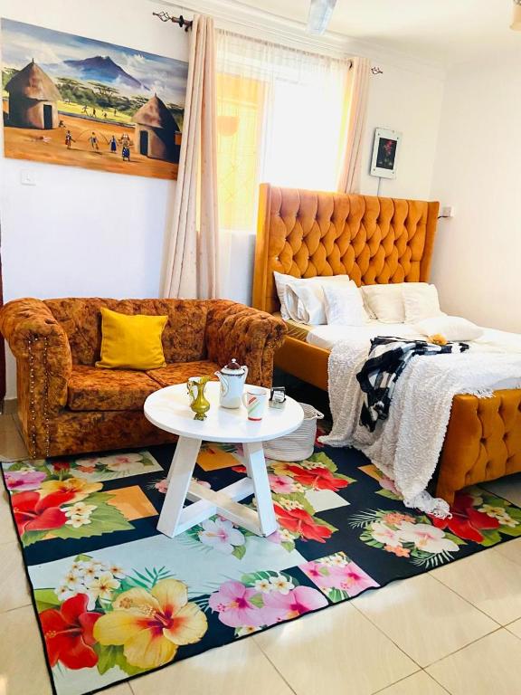 a bedroom with a couch and a table on a rug at Softlife Home Classic Studio 2 in Mombasa