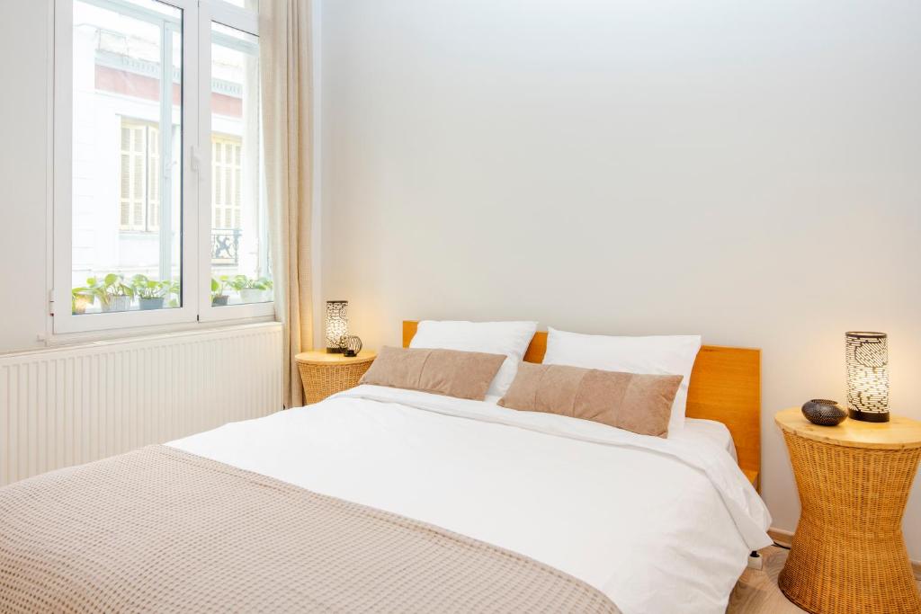 a white bedroom with a large bed and a window at K8 Syntagma in Athens