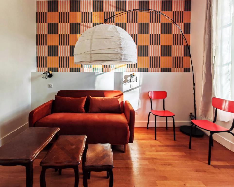 un salon avec un canapé et des chaises rouges dans l'établissement 2 chambres - entrée privée - gare & palais de congés à 5 min, à Tours