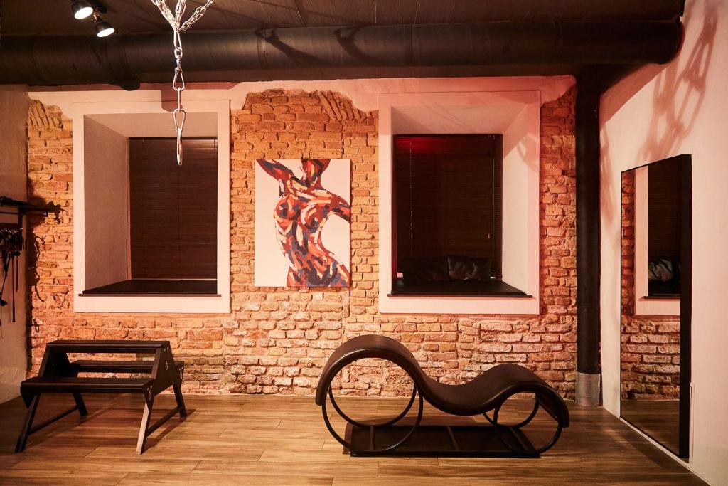 a room with a chair in front of a brick wall at BDSM Black Apartments in Vilnius