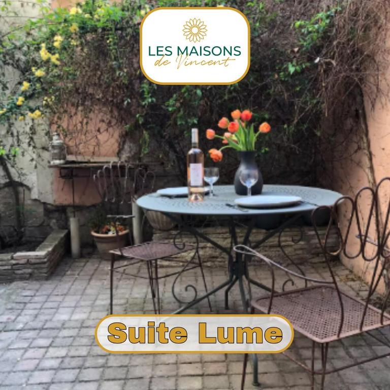 - une table avec 2 chaises et une bouteille de vin dans l'établissement La Suite Lume - Clim et terrasse, à Arles