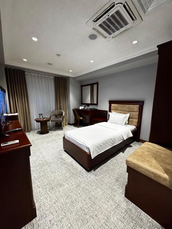 a hotel room with a bed and a desk at Mir Luxe Plaza in Tashkent