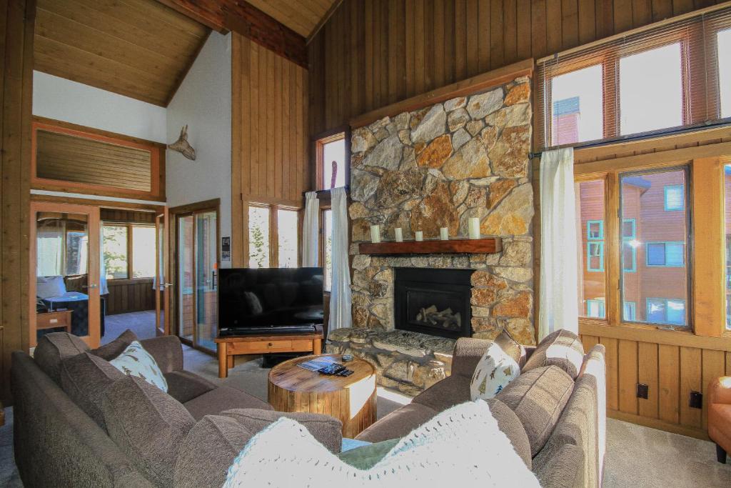 a living room with couches and a stone fireplace at Mountainback 19 Loft Den in Mammoth Lakes