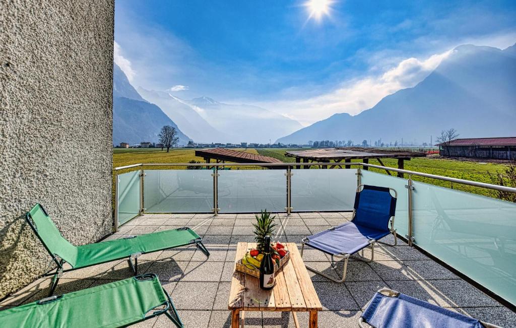 two chairs and a table on a balcony with a view of mountains at Casa Meno in Novate Mezzola