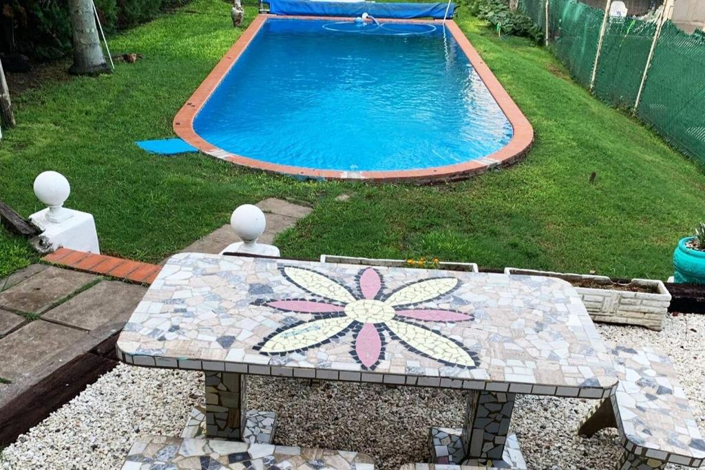 einen Tisch mit einer Blume auf dem neben einem Pool gemalten in der Unterkunft Casa Quinta Arroyo del Medio in Acindar