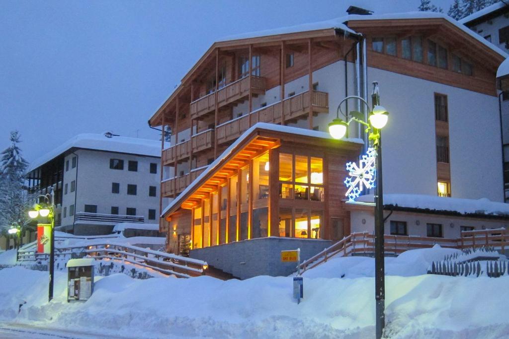 a building in the snow at night at Hotel Garnì Caminetto in Madonna di Campiglio