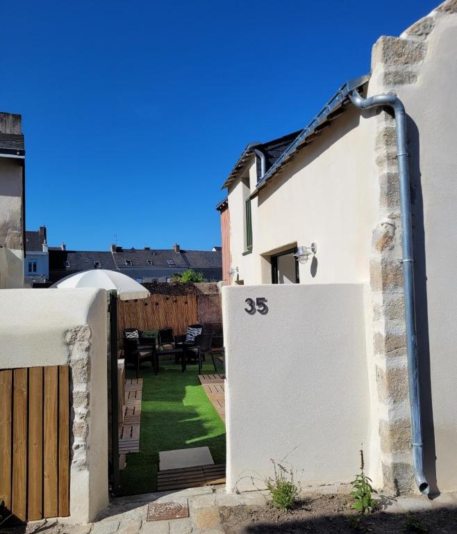 une maison blanche avec un portail et une cour dans l'établissement Maison de charme en bord de mer, à Batz-sur-Mer