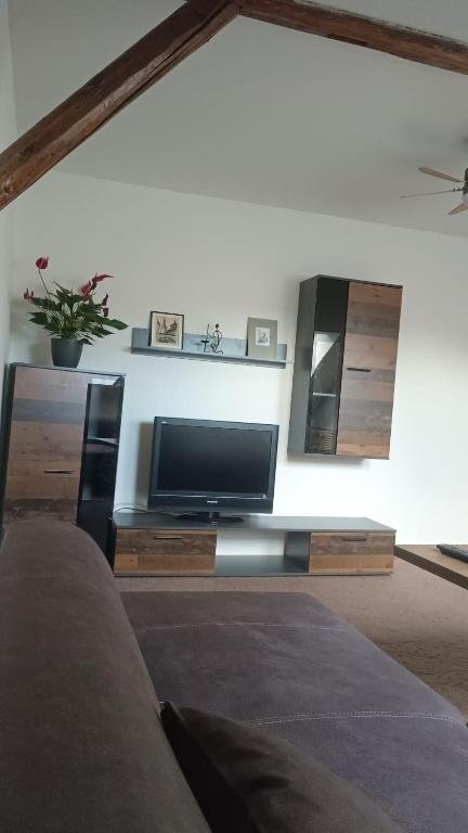 a living room with a flat screen tv on a wall at Apartmán v podkroví Olomouc in Olomouc