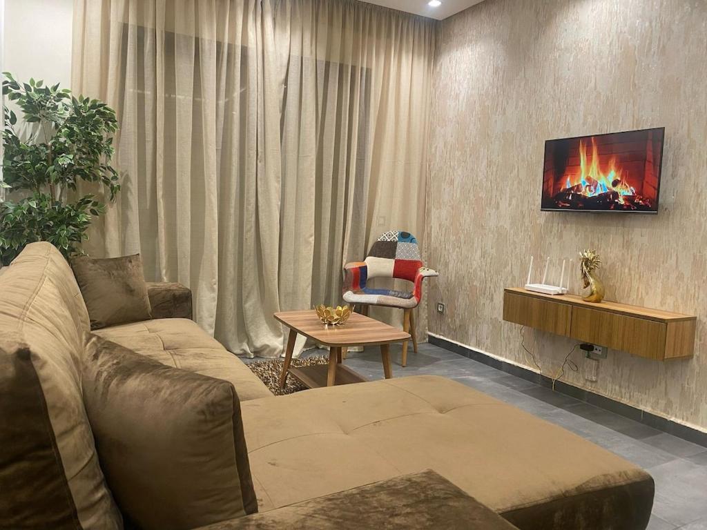 a living room with a couch and a tv on a wall at Downtown delight studio in Casablanca