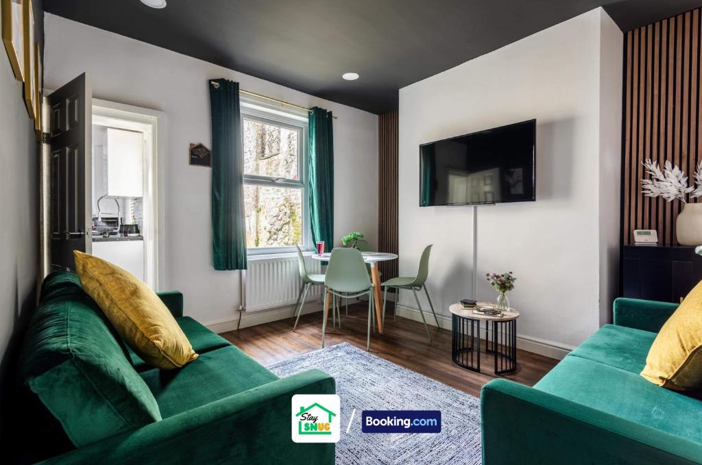 a living room with a green couch and a table at Four Bedroom House in Preston in Preston