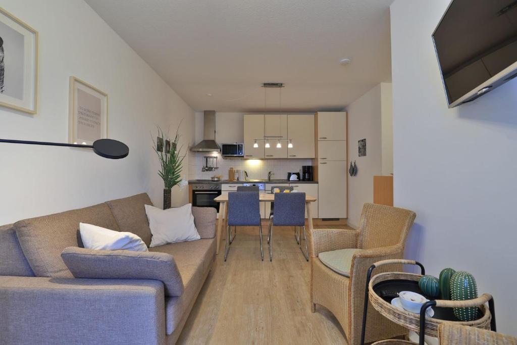 un salon avec un canapé et des chaises et une cuisine dans l'établissement Residenz Haffblick Wohnung 31, à Boltenhagen