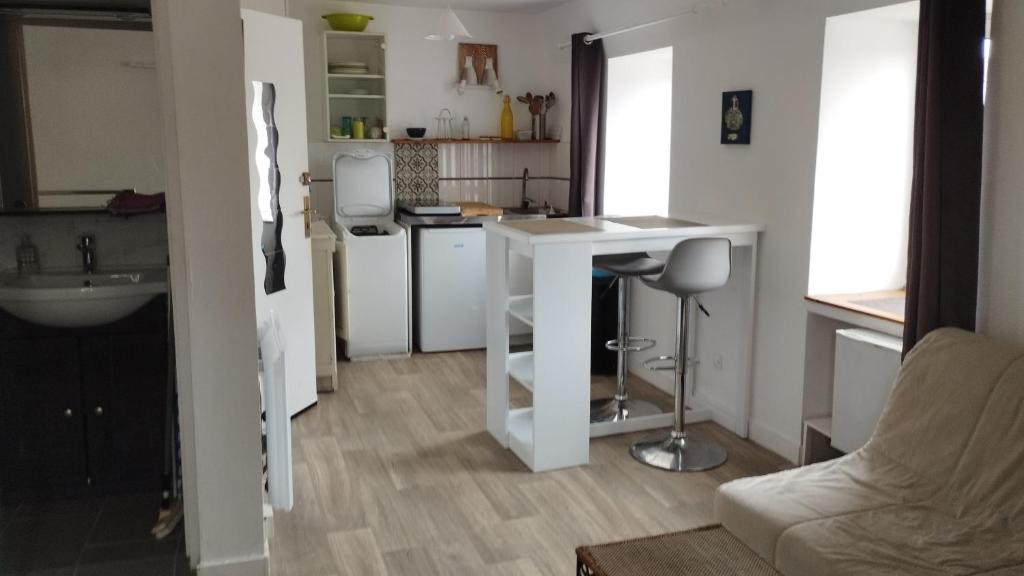 une petite cuisine avec un comptoir blanc et une table dans l'établissement DOUARNENEZ Centre ville, à Douarnenez