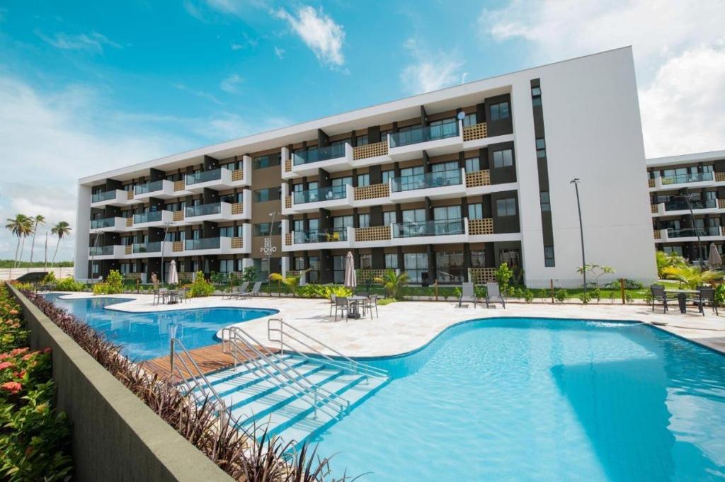 un hôtel avec une piscine et un bâtiment dans l'établissement MANA BEACH MURO ALTO - by MB 016, à Porto de Galinhas