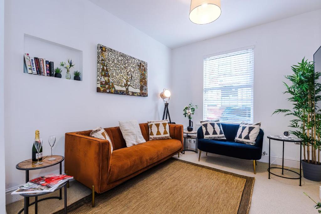 a living room with a brown couch and a blue chair at Stylish 3-Bed City Centre Home in Chester by 53 Degrees Property, Ideal for Groups, Private Parking! in Chester