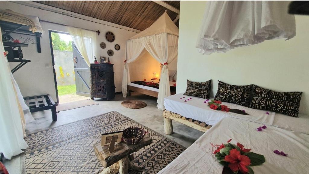 a bedroom with two beds in a room with a window at Piscine rien que pour vous, propriété entière face au lagon, les pieds dans l 'eau, cuisine équipée & wifi Le Boraha Beach Lodge 90 m2 in Sainte Marie