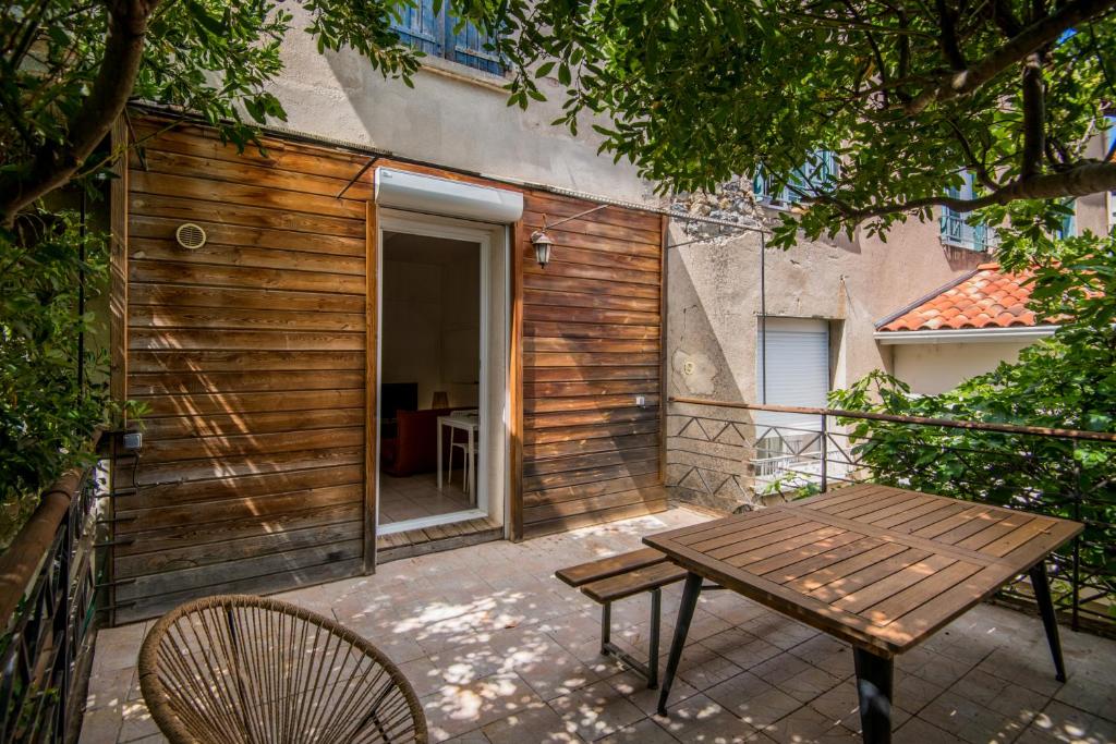 une terrasse en bois avec une table et des chaises en bois dans l'établissement le Canopée 3 pers appart F1 terrasse fibre centre-ville, à Millau