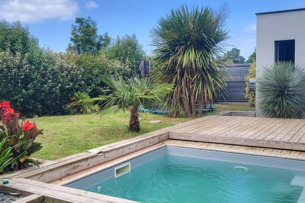 - une piscine dans un jardin avec une terrasse en bois dans l'établissement Villa 4 chambres - 130m2 - 8 personnes, à Soustons