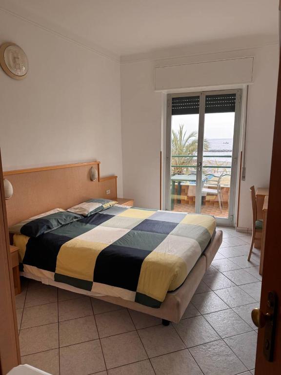 sypialnia z łóżkiem i widokiem na ocean w obiekcie Hotel Ideal w mieście Arma di Taggia