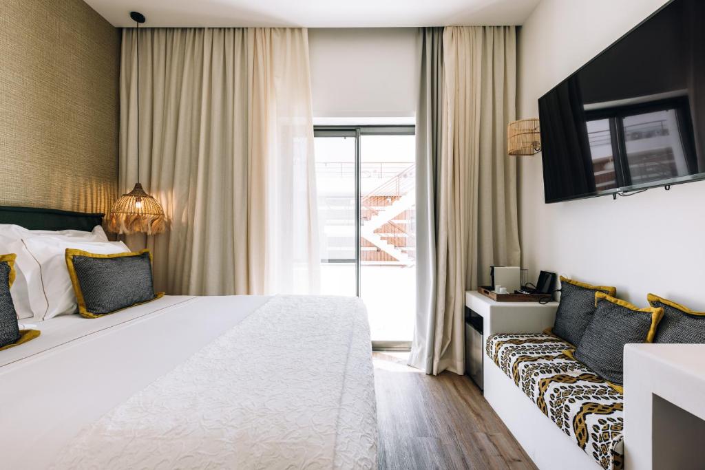 a hotel room with a large bed and a couch at AlmaLusa Comporta in Comporta