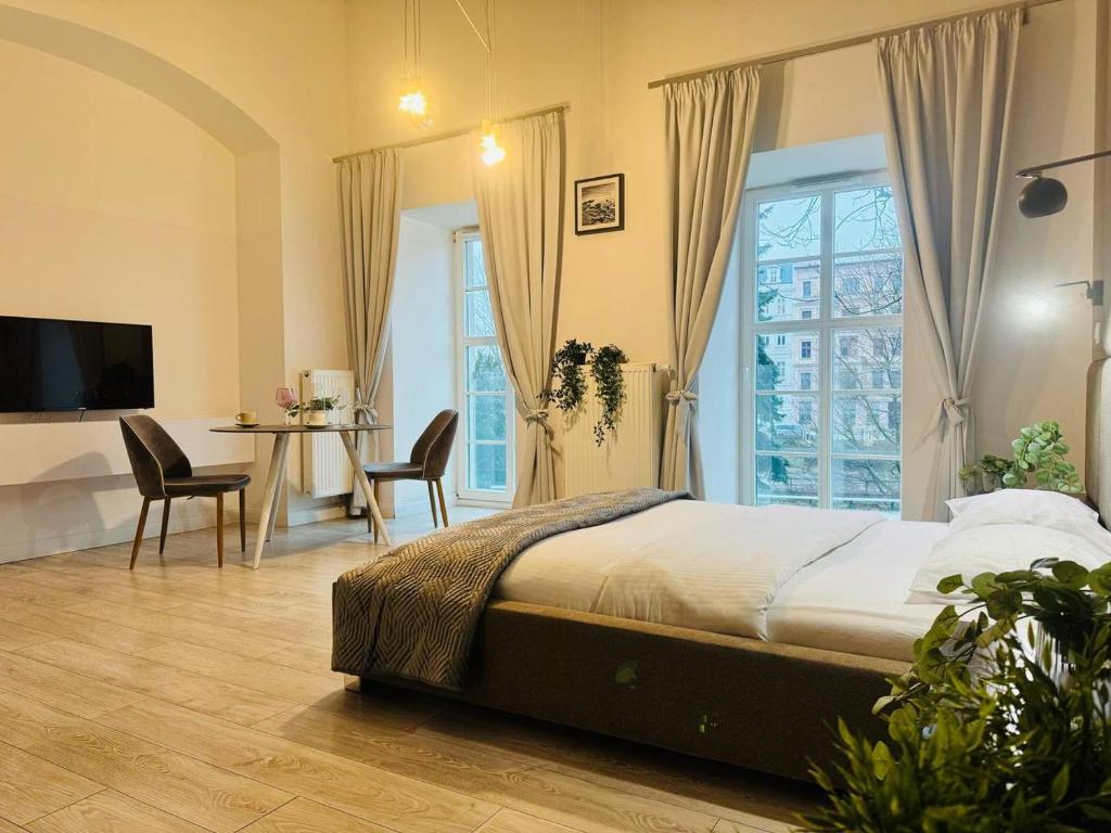 sypialnia z łóżkiem, stołem i krzesłami w obiekcie AbsyntApartments 24 Rynek Wrocław we Wrocławiu