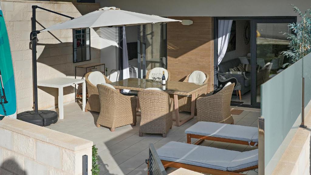 a patio with a table and chairs and an umbrella at Seaside Apartment in Arenales del Sol