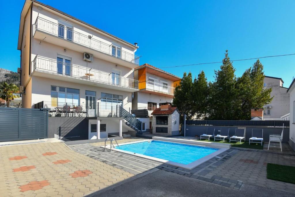 a house with a swimming pool in front of it at Apartment Dijana with private pool in Donji Proložac