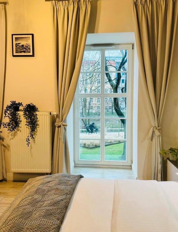 sypialnia z łóżkiem i dużym oknem w obiekcie AbsyntApartments 24 Rynek Wrocław we Wrocławiu