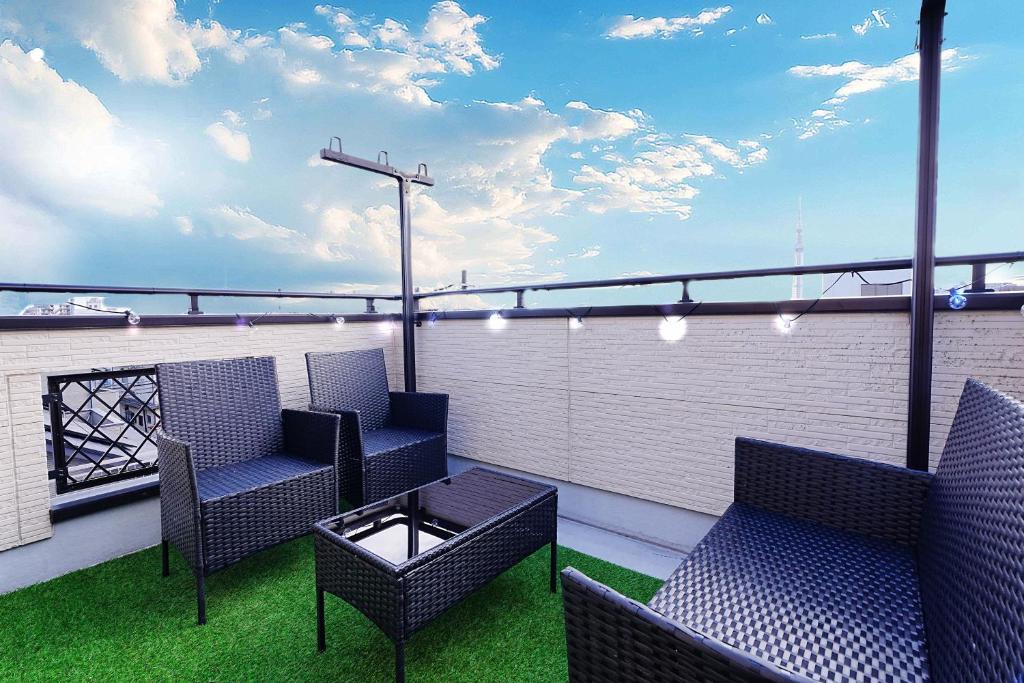eine Terrasse mit zwei Stühlen und einem Tisch auf einem Balkon in der Unterkunft European villa in Tokio